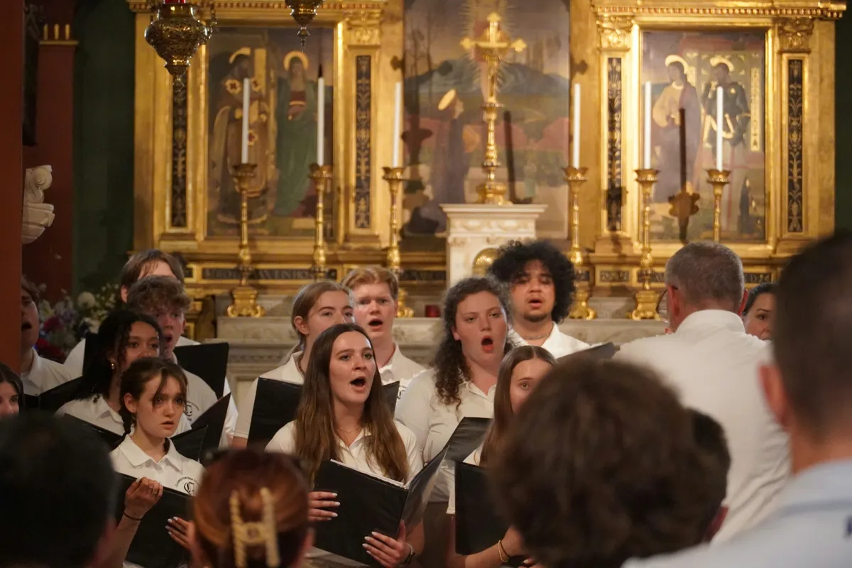 Chorale de plusieurs générations qui chante, cartables noirs en main